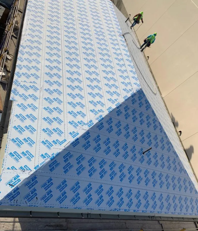 Professional roofers installing underlayment on a metal roof in Santaquin